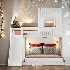 a white bunk bed with a slide on the bottom and stairs to the top, in front of a christmas tree