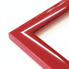 a close up of a red frame on a white surface with an orange object in the middle