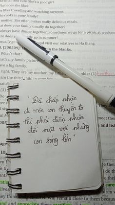 an open notebook with writing on it and a pen resting on top of the book