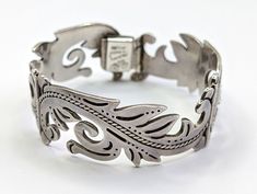 One of a kind, thick vintage 1950s sterling silver hinged articulated bracelet, handcrafted in Mexico and decorated with carved fern and floral motifs. The bracelet comes with a safety chain. A unique piece, perfect for fans of old Mexican silver jewelry.  Delightful craftsmanship. Hallmarked Hecho en Mexico Sterling 925, with a stamped butterfly hallmark Eagle 3, the articulated bracelet is 7/8" wide with has an inner circumference of 7". In excellent vintage condition, with minimal signs of wear (a little bit of patina - should polish nicely). Provenance: Estate Mexican Silver Jewelry, Handmade Artisan, Vintage 1950s, Bracelet Gift, Floral Motif, Unique Pieces, Bangle Bracelets, Silver Jewelry, Jewelry Bracelets