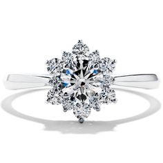 an engagement ring with a flower design on the front and center, set in white gold