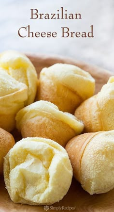 a wooden bowl filled with rolls covered in butter