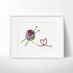 a ball of yarn and two knitting needles with the word love written in red ink