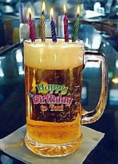 a beer mug with candles in it sitting on top of a napkin that says happy birthday to you