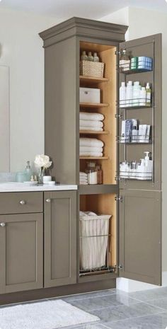 an open cabinet in the middle of a bathroom with lots of towels and other items