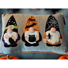 three little mice in witches hats sitting on a pillow with pumpkins behind them and a spider web hanging from the back