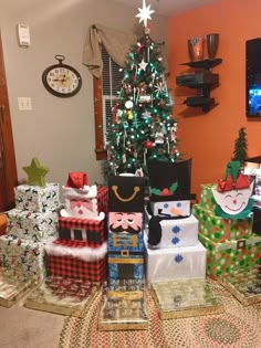 christmas presents are stacked next to a decorated christmas tree