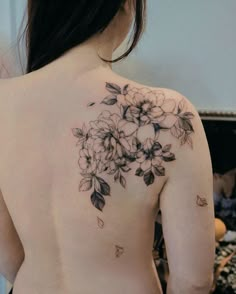 the back of a woman's shoulder with flowers on it