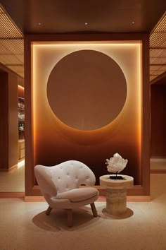 a white chair sitting in front of a wall with a circular painting on it's side