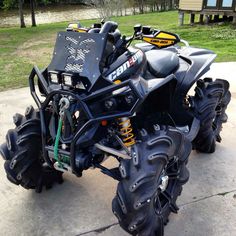 a large four wheeler parked on top of a cement slab in front of a house