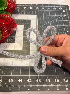 someone is making a bow out of ribbon on a cutting board next to christmas decorations