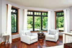 a living room filled with furniture and large windows