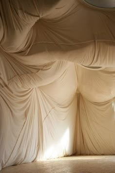 an empty room with drapes covering the walls