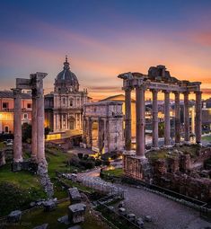 the roman forum at sunset in rome, italy with columns and other buildings around it