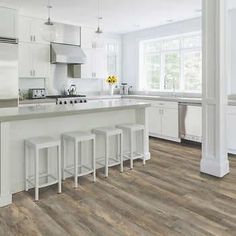 a kitchen with white cabinets and wooden floors