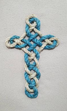 a crocheted blue and white cross is shown