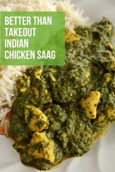 a white plate topped with chicken and spinach next to rice on top of a table