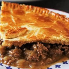 a piece of meat pie on a blue and white plate with stars around the edges