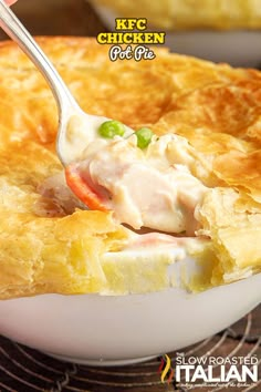 a close up of a spoon in a pie with chicken and cheese on it's crust