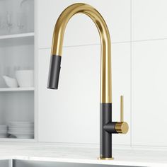 a black and gold faucet in a white kitchen