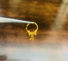 a small gold ring sitting on top of a wooden table