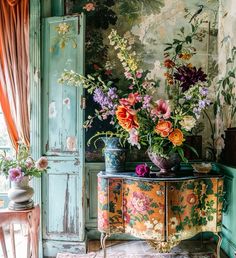 flowers are in vases on an old dresser