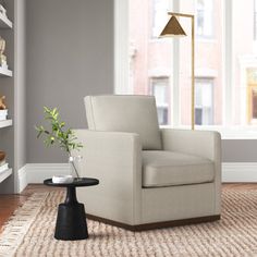 a living room with a chair, lamp and bookshelf in the back ground