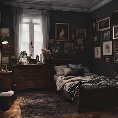 a bed sitting in a bedroom next to a window with pictures on the wall above it