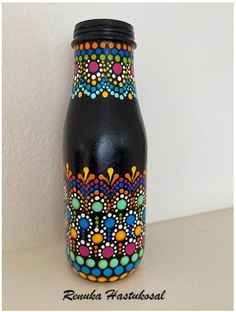 a black vase with colorful designs painted on it