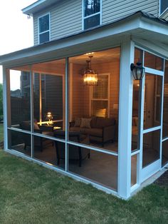 a screened in porch with furniture and lights