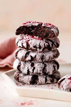 chocolate crinkle cookies stacked on top of each other with red sprinkles