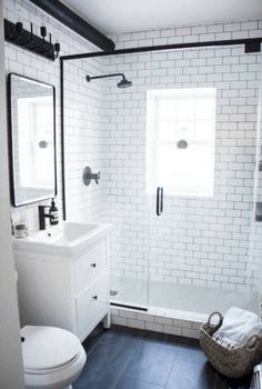 a bathroom with black and white tile flooring, a sink, toilet and shower