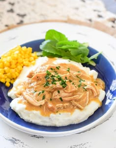 mashed potatoes topped with gravy and garnished with parsley on a blue plate