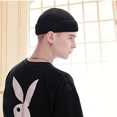 a young man wearing a black sweater with a white bunny earring on his head