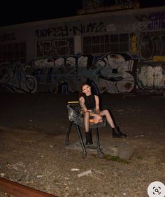 a woman sitting on top of a metal chair