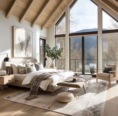 a bedroom with large windows overlooking the mountains