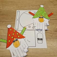 two paper puppets made to look like clowns with hats and stars on their heads