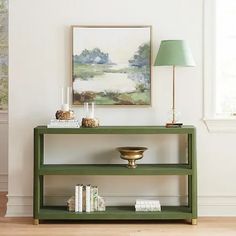 a green shelf with books and a lamp on it in a white walled living room