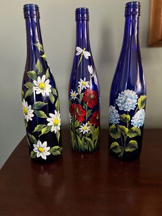 three blue vases with painted flowers on them