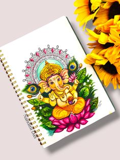 a notebook with an image of the god ganesh on it next to sunflowers