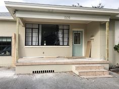 an empty house with steps leading up to the front door and windows on either side