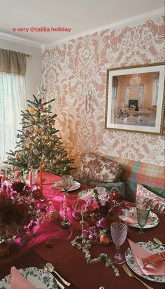 a christmas tree sitting on top of a wooden table next to a red cloth covered couch