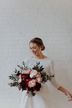 a woman in a white dress holding a bouquet of flowers