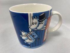 a blue and white coffee cup with two horses on it