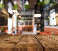 an empty wooden table in front of a blurry background