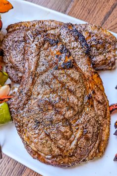 two steaks on a white plate with vegetables