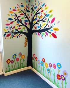 a colorful tree painted on the wall in a child's room