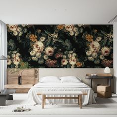 a bed sitting in a bedroom next to a wall with flowers on it's side