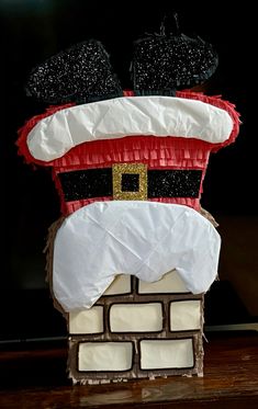 a close up of a santa clause hat on top of a brick wall with snow flakes