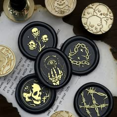 several buttons with designs on them sitting on top of a piece of paper